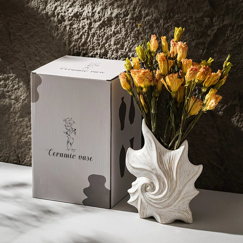 CAPIRON Ceramic Conch Vase by Nutshell with dried yellow flowers next to packaging box