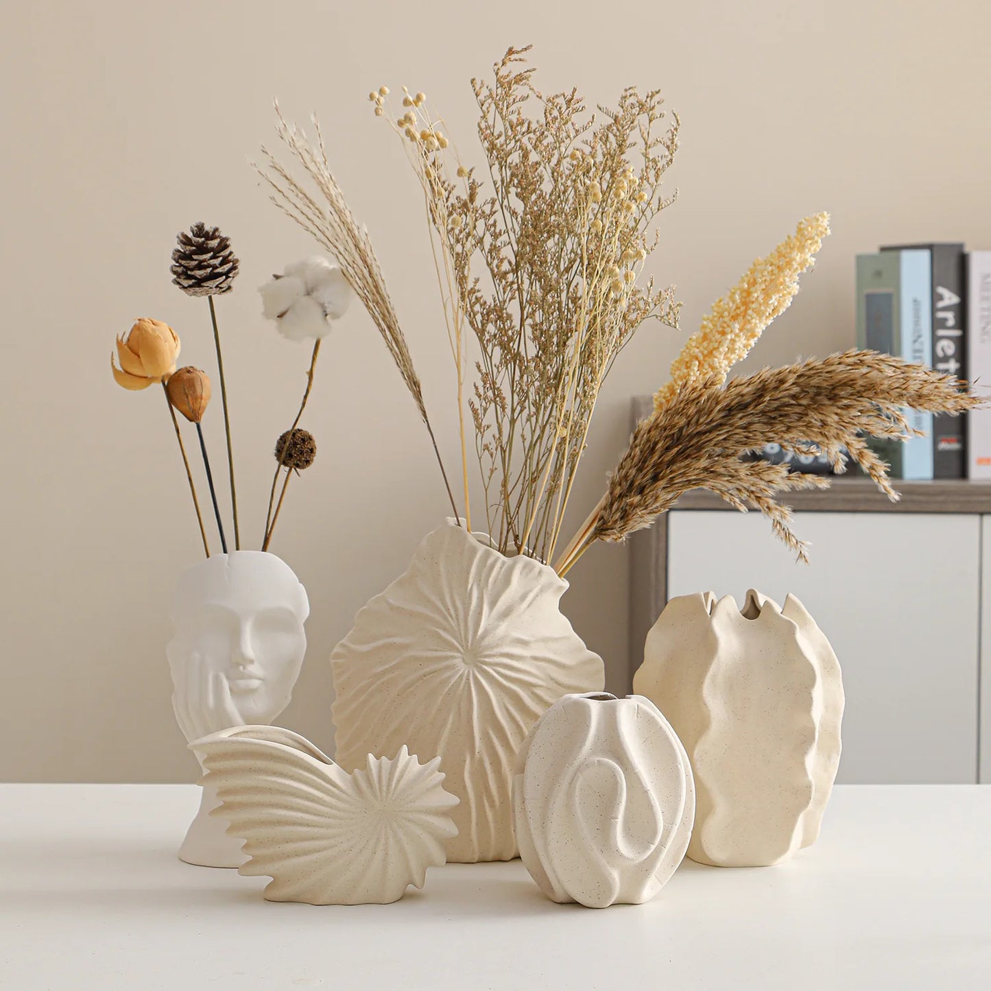 Nutshell ceramic conch design vase in beige displayed with dried flowers on a white table
