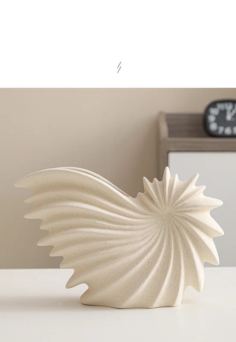 Nutshell ceramic conch design vase in a beige spiral pattern displayed on white surface