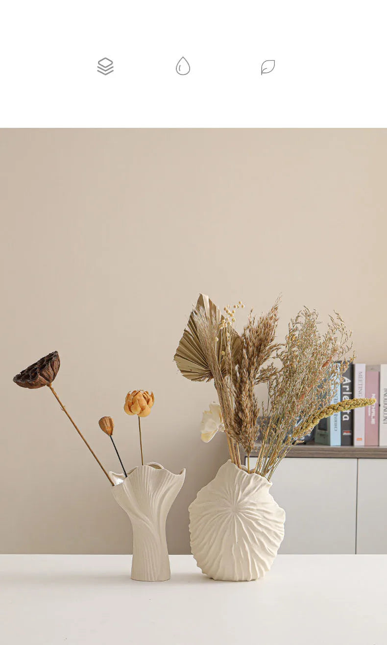 Nutshell ceramic conch design vase with dried flowers on white table against beige wall