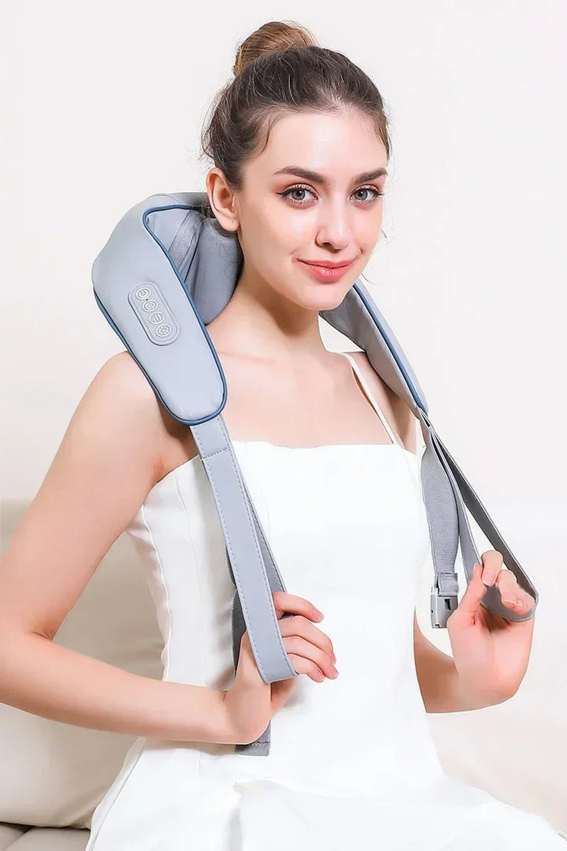 Woman wearing Nutshell 3D kneading neck massager with heat in gray over shoulders holding straps