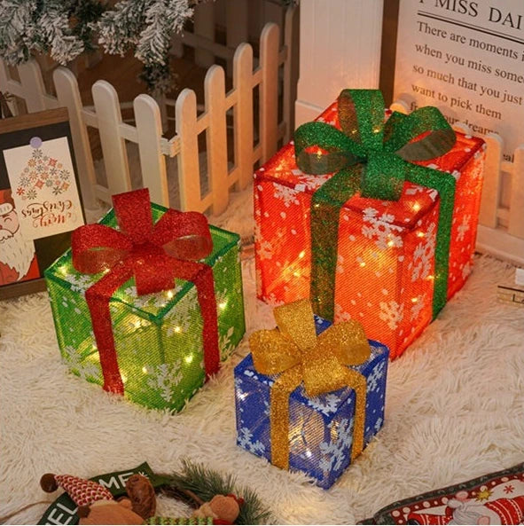 Colorful Christmas light up gift boxes in red, green, and blue with decorative bows and snowflake patterns