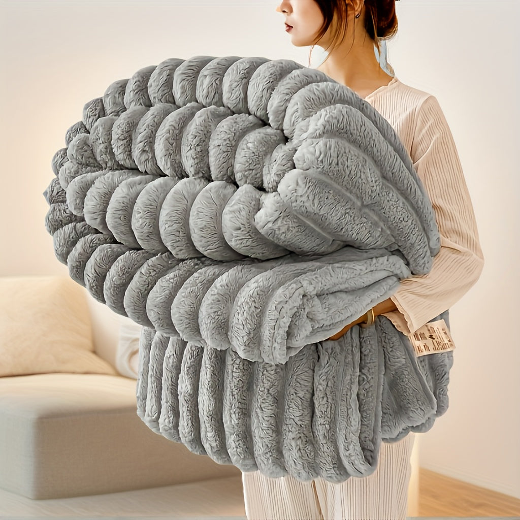 Woman holding oversized gray luxury faux fur throw blanket with ribbed plush texture in modern living room
