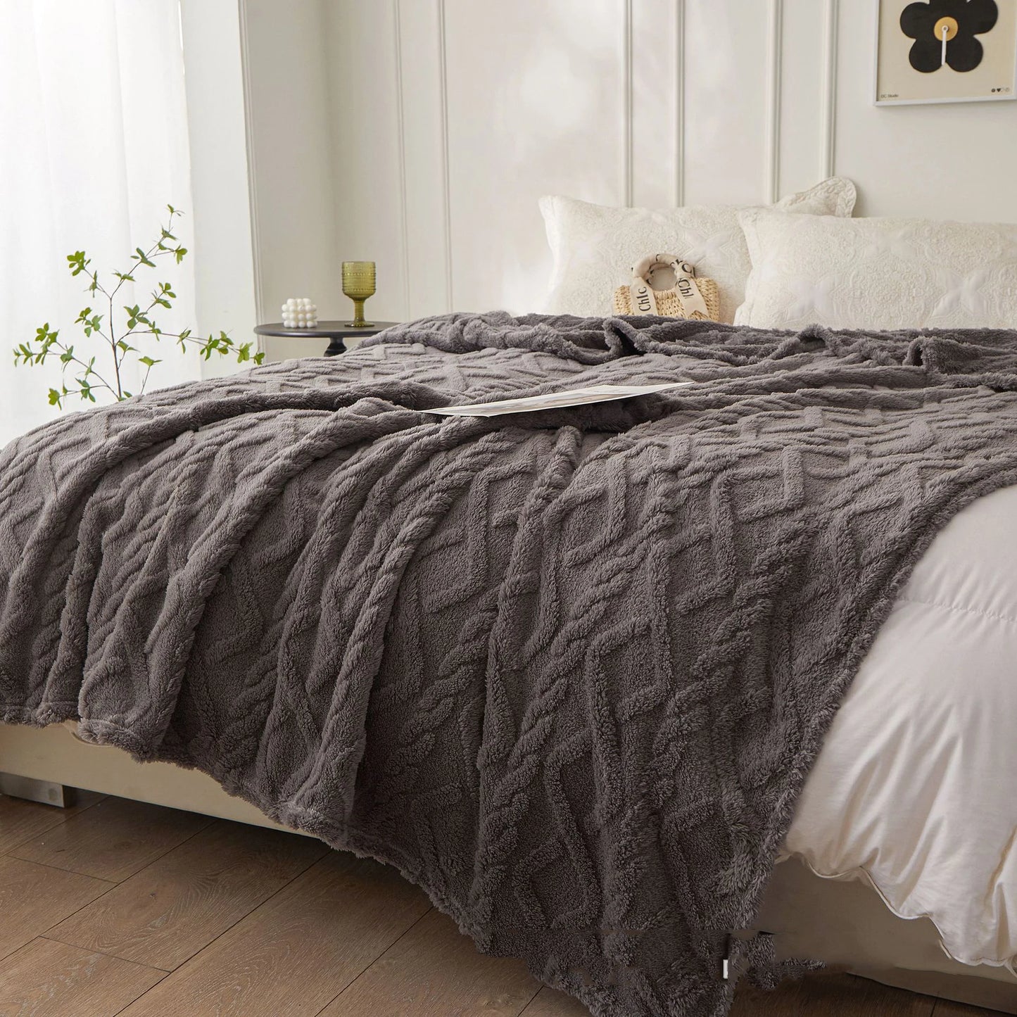 Nutshell plush charcoal cable knit warm sofa throw blanket draped on bed showing soft cozy texture