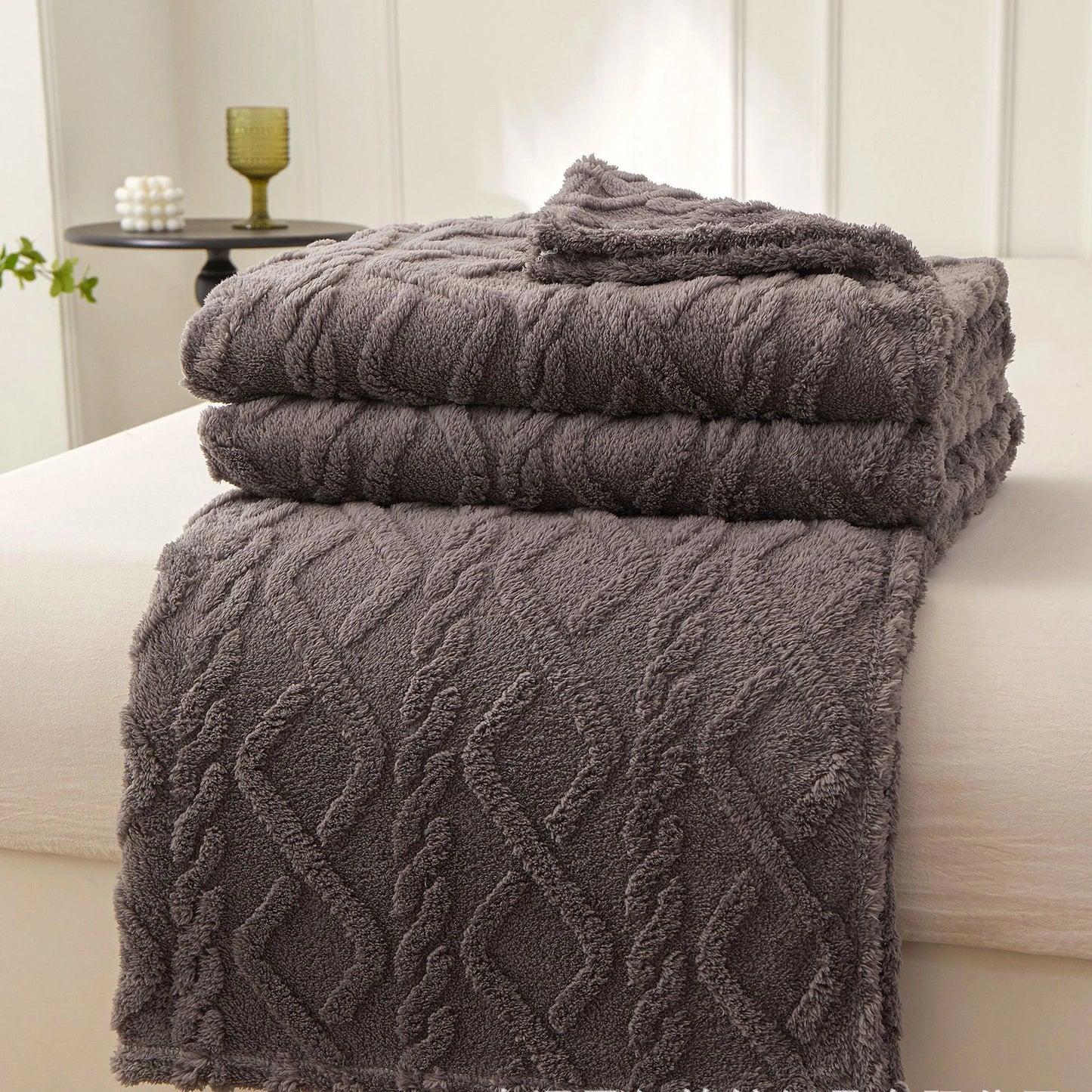 Nutshell gray cable knit plush warm sofa throw blanket folded on bed with textured pattern