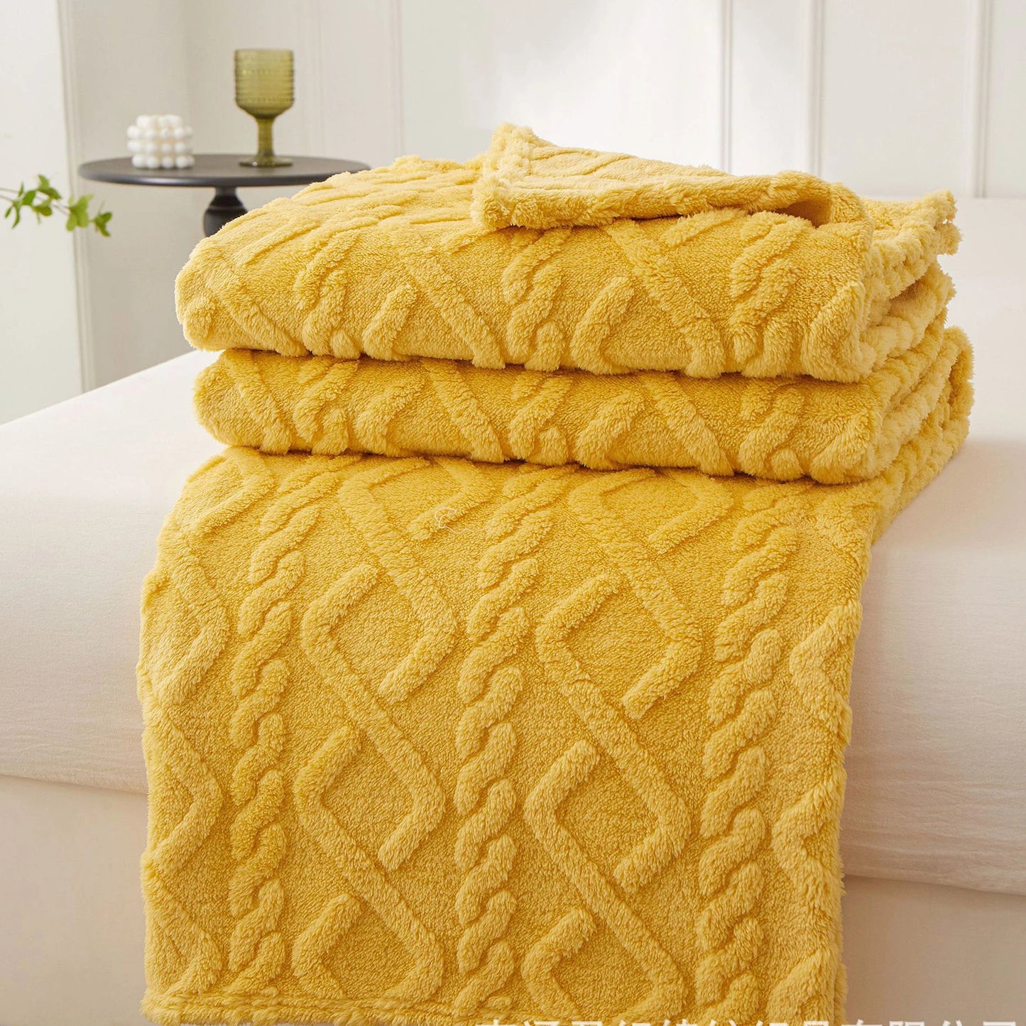 Nutshell warm sofa throw blanket in mustard yellow cable knit plush folded on a couch for cozy living rooms