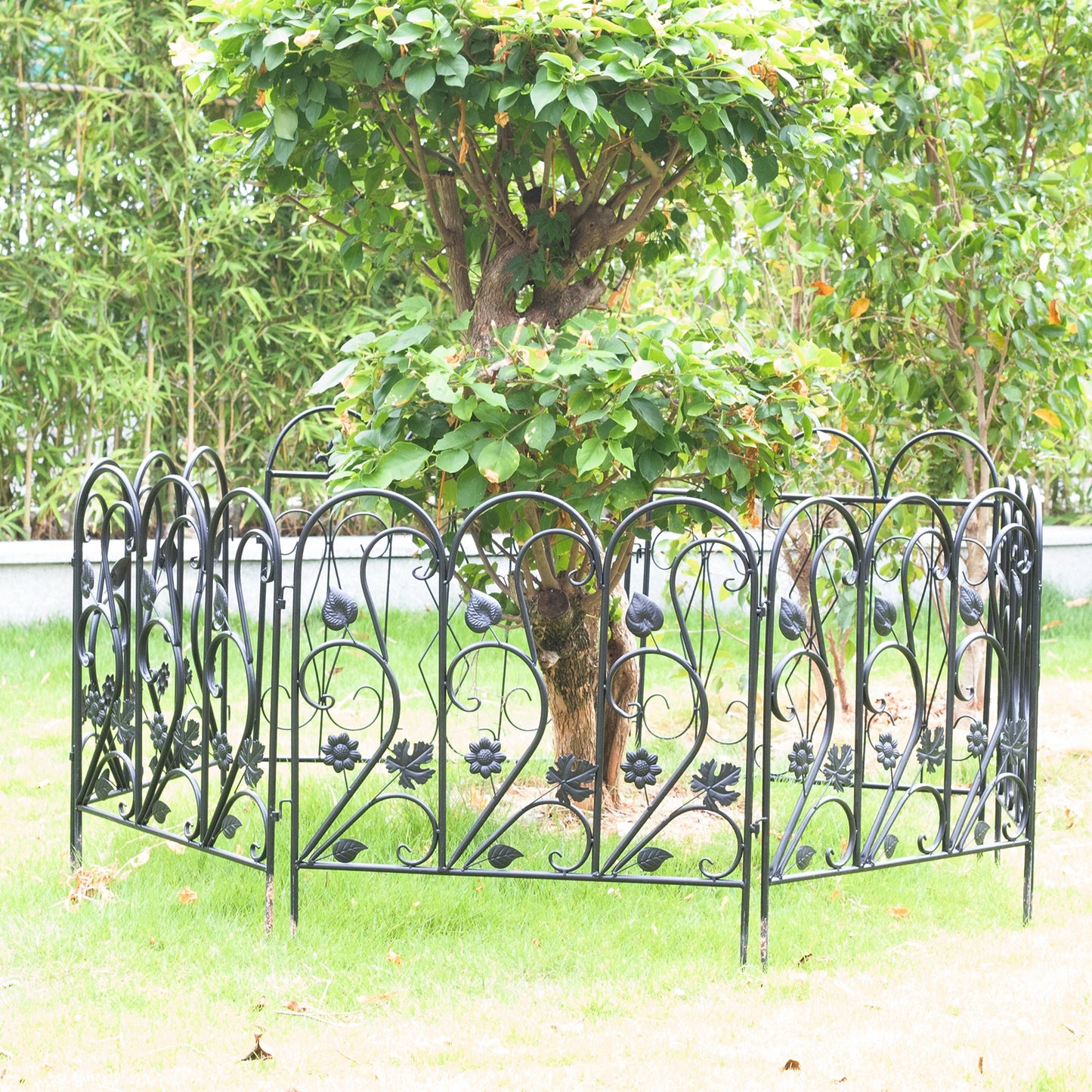 Nutshell black decorative garden fence panels with floral design surrounding tree on green lawn