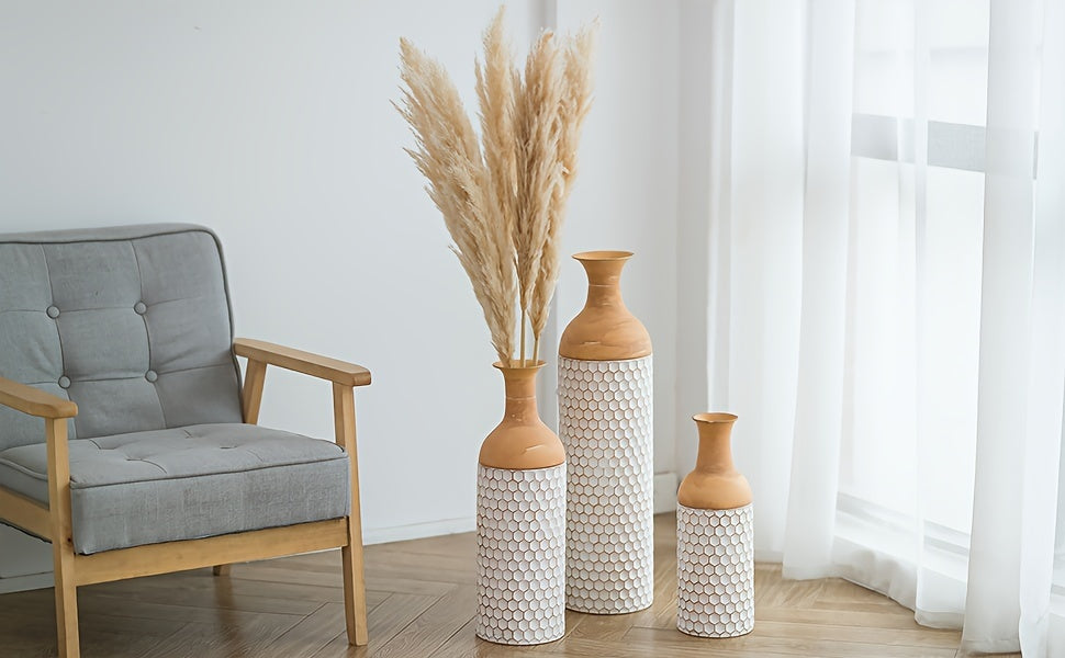 Elegant arrangement of extra large metal floor vases with decorative patterns and tall dried plants