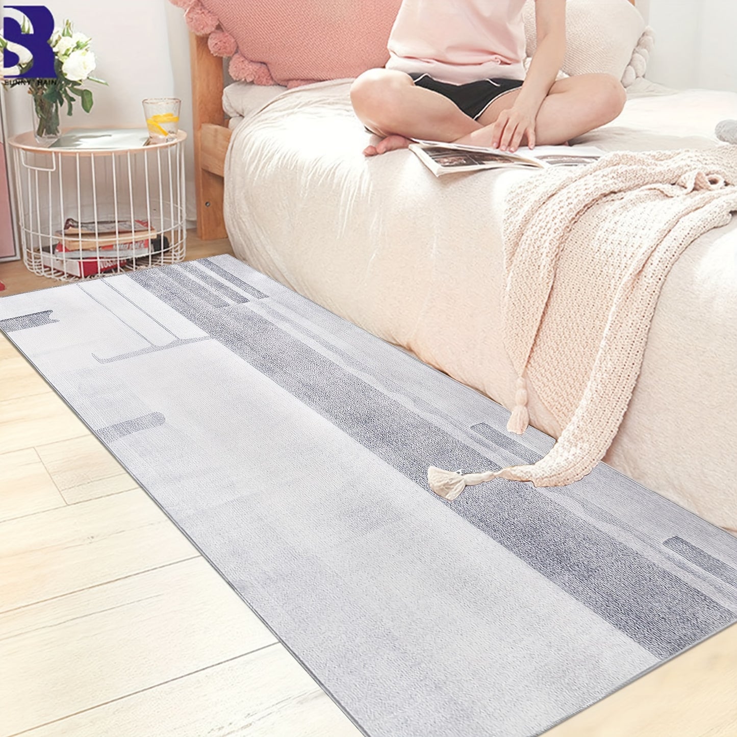 Stylish grey hallway runner rug placed next to a bed with a woman sitting on the edge