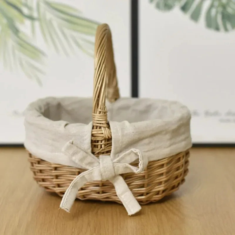 Nutshell handcrafted wicker basket with beige fabric lining and bow sitting on wooden surface