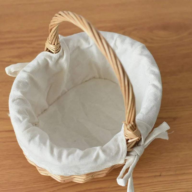 Nutshell handcrafted wicker basket with white fabric lining and sturdy handle on wooden surface
