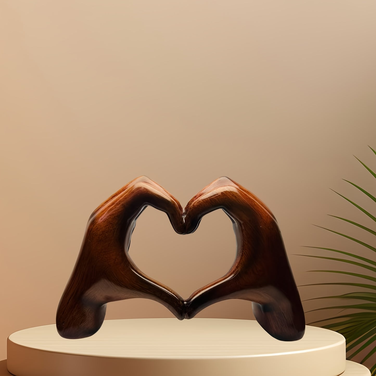Heart-shaped resin sculpture decor by Nutshell featuring two hands forming a heart on a round pedestal