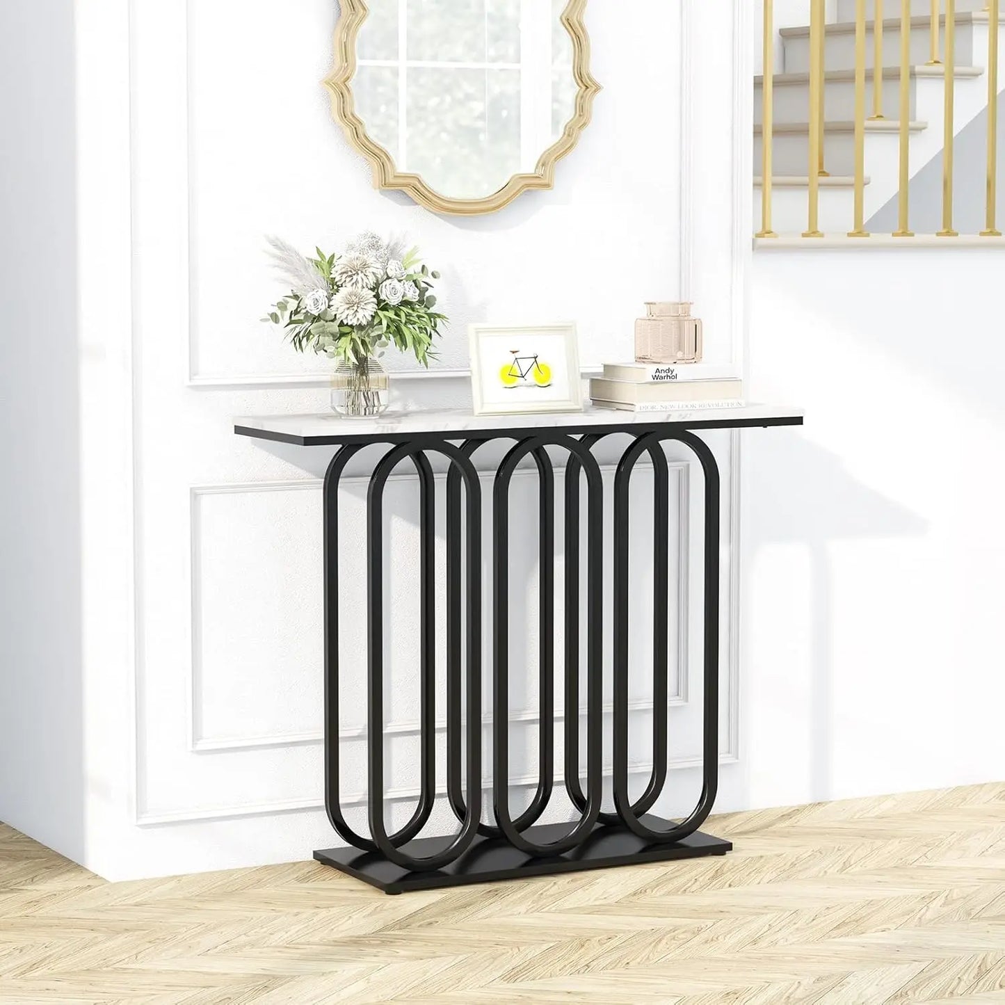 Nutshell faux marble console table with white marble top and black geometric looped metal base in foyer