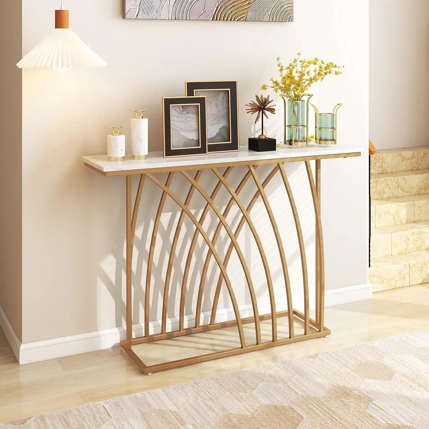 Nutshell modern gold console table with white marble top and arched metal base in styled entryway