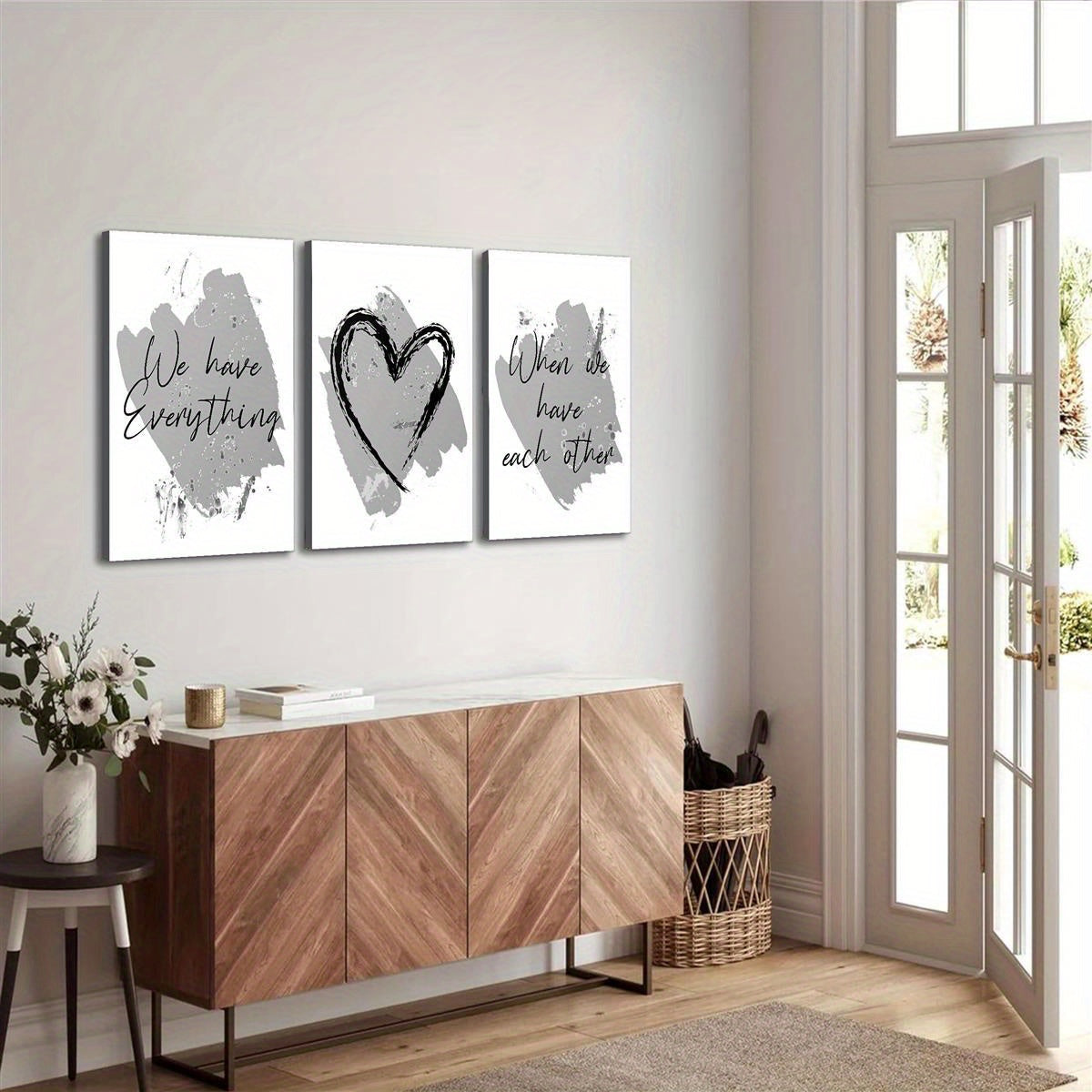 Set of three inspirational quote posters featuring abstract designs on a living room wall
