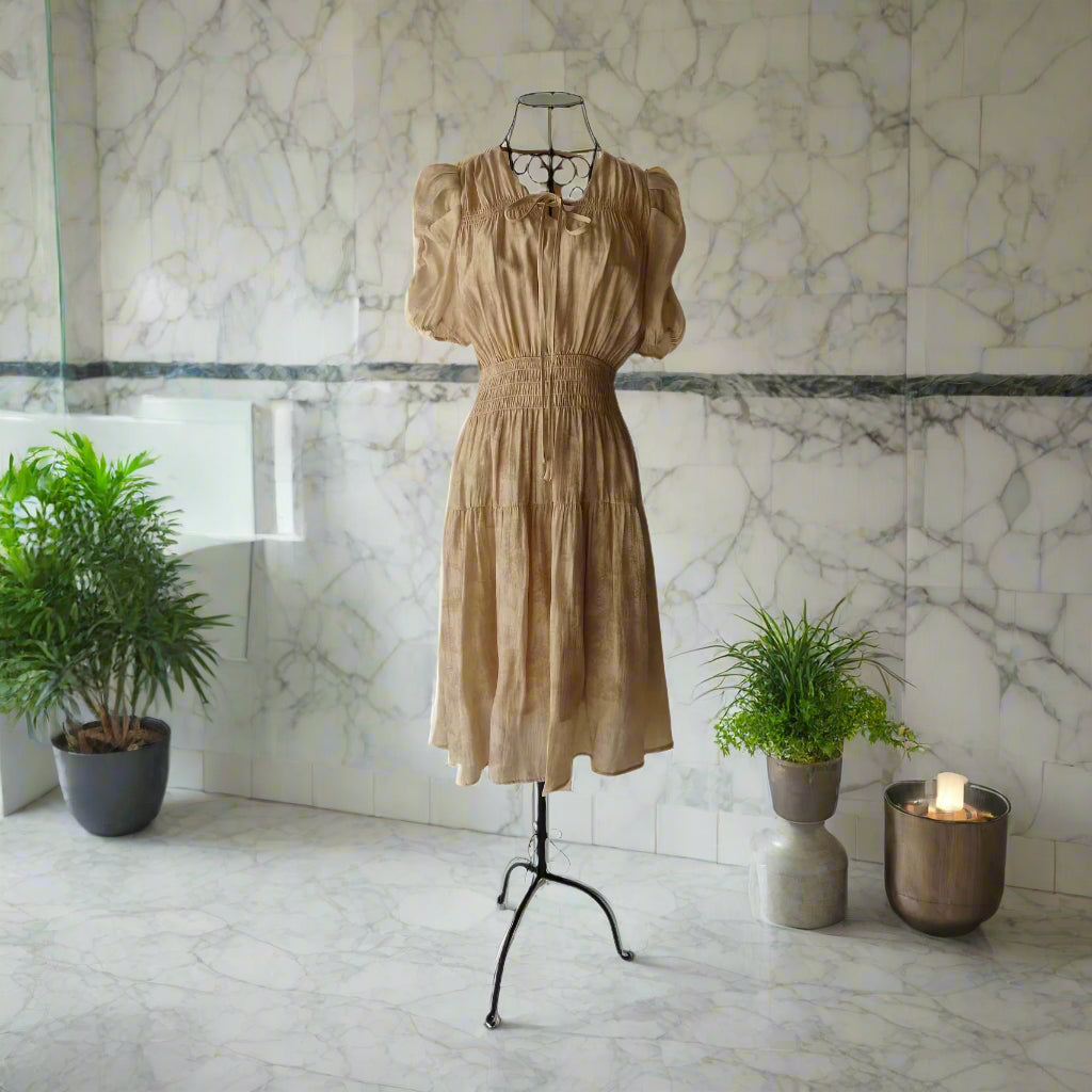 Iron Female Mannequin Displaying a Cream Colored Dress with a Smocked Waist and Short Sleeves