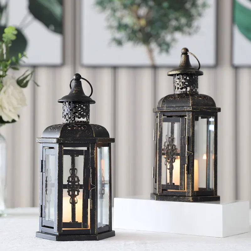 Nutshell vintage candle holder lanterns in black metal with intricate designs and glass panels on a white surface