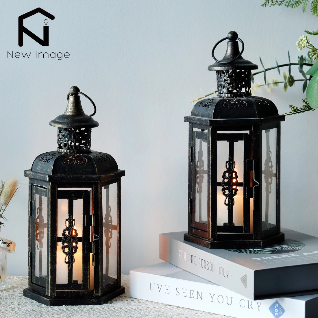 Nutshell vintage candle holder lanterns with intricate metal design and glass panels displayed on books