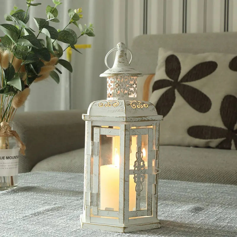 Nutshell vintage candle holder lanterns in distressed white metal with intricate detailing and lit candle inside