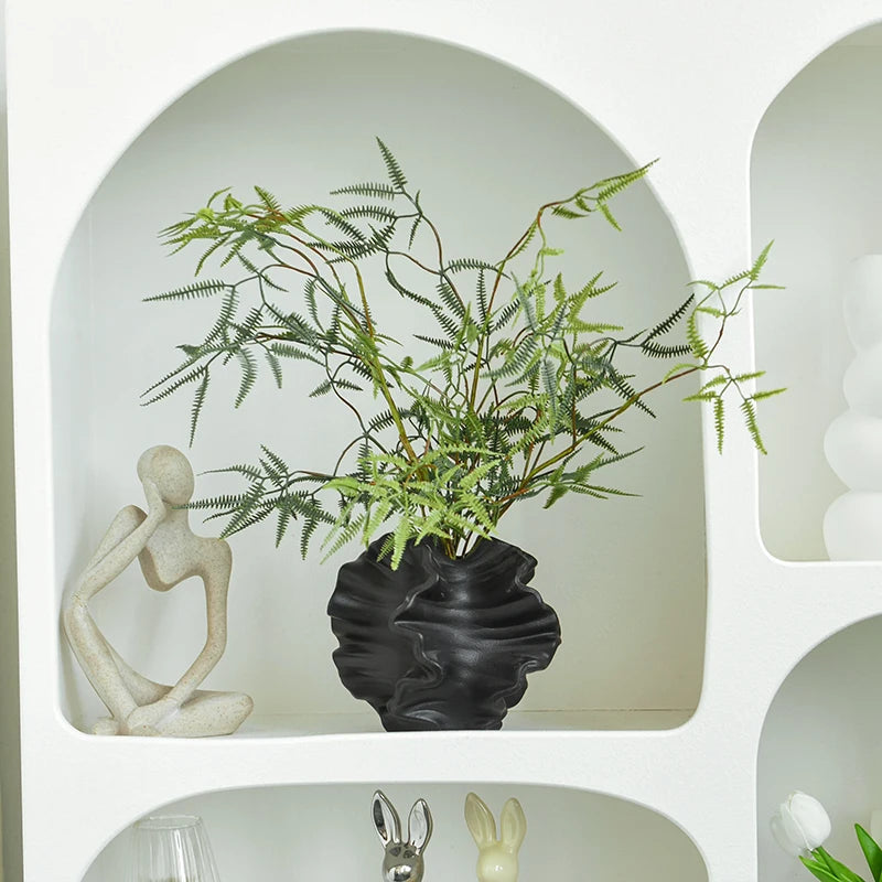 Black Nordic art coral vase by Nutshell with green fern leaves on white decorative shelf