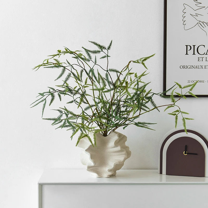 Nordic art coral vase by Nutshell in white with green fern branches on white cabinet