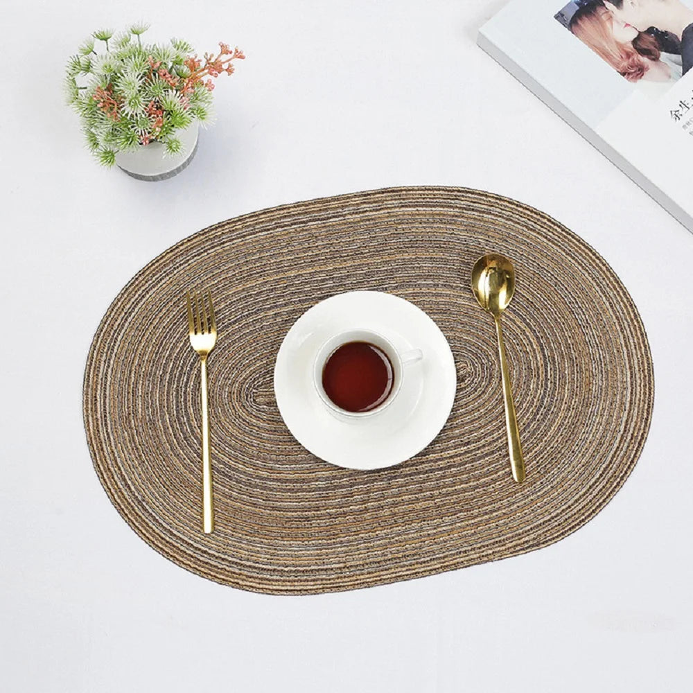 Nutshell Oval Braided Placemats in Natural Tone with Gold Cutlery and White Dish for Elegant Dining