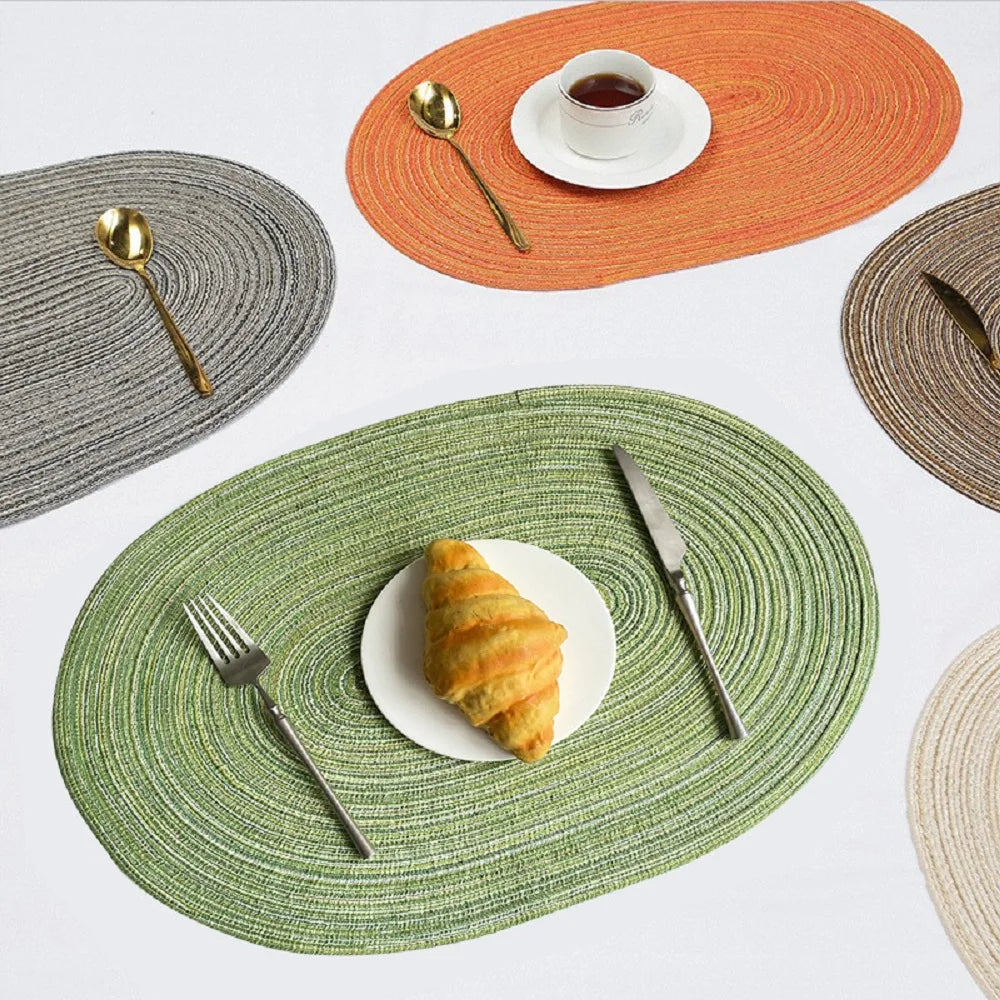 Set of Oval Braided Placemats in multiple colors, featuring a fork, knife, and plate with food
