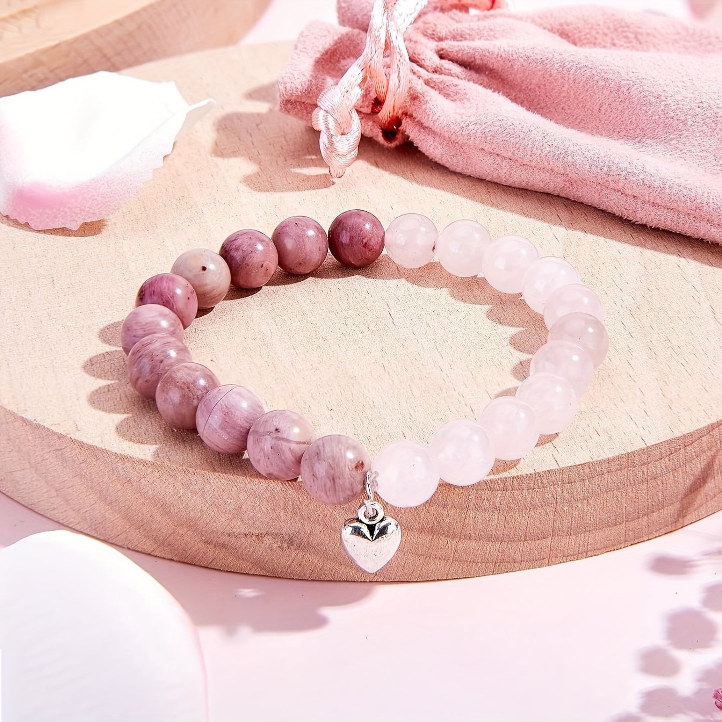 Pink Relaxation Gift Set With Travel Mug featuring a lovely bracelet and a soft pouch on a wooden display