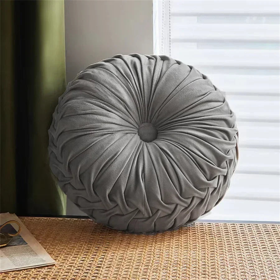 Gray Nutshell round pumpkin pillow cushion with gathered fabric design on wicker surface