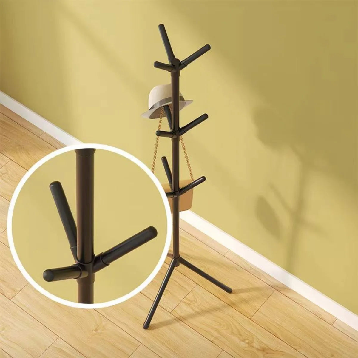 Nutshell black metal tree branch coat rack with tripod base and multiple peg hooks for hats and bags