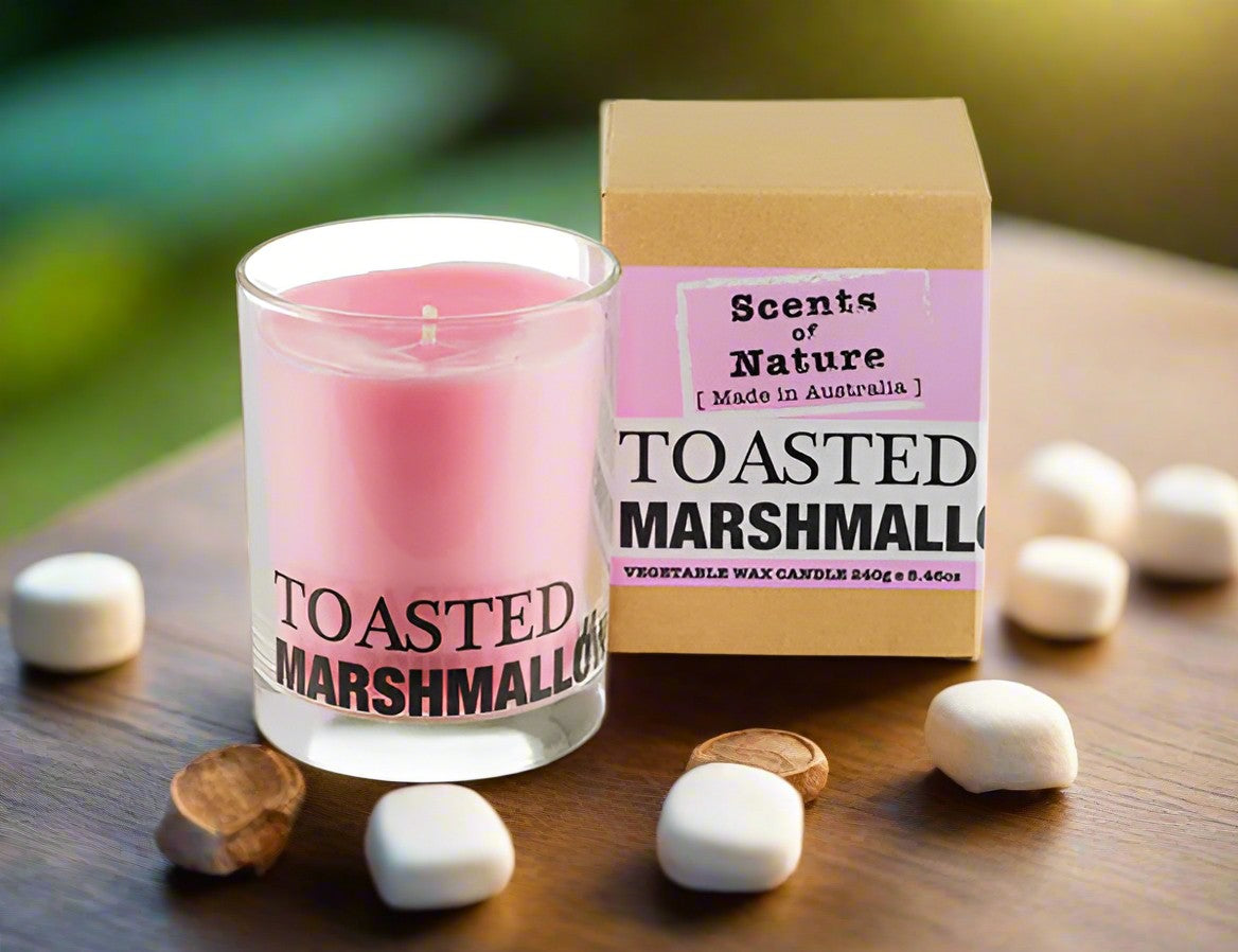Nutshell Toasted Marshmallow Gift Pack pink scented candle in glass with box and scattered marshmallows on wood