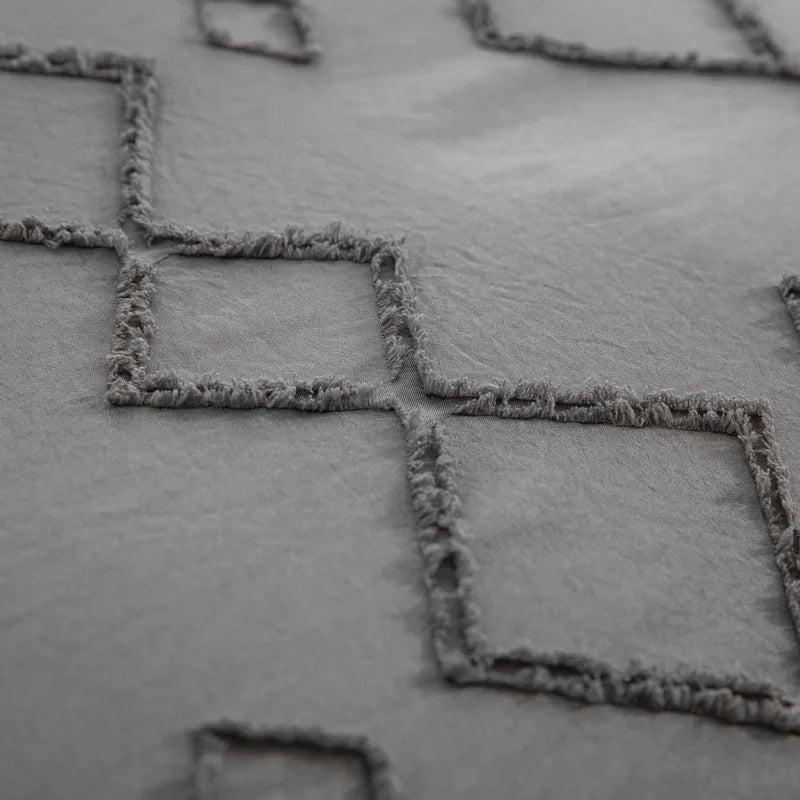 Close-up of Nutshell tufted gray duvet cover set with textured diamond pattern and soft fabric