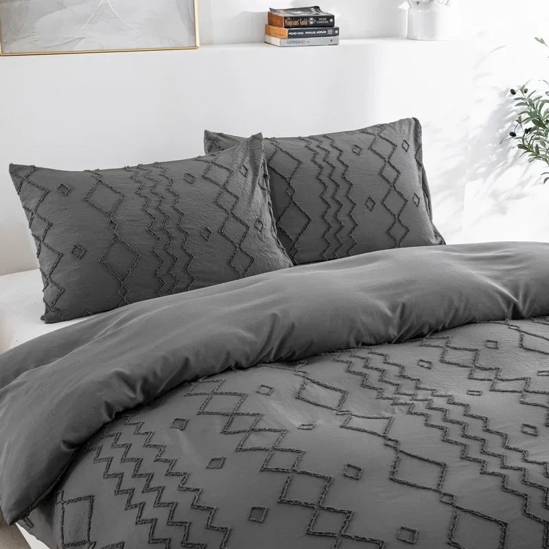 Nutshell tufted gray duvet cover set with textured geometric patterns and matching pillow shams on a white bed