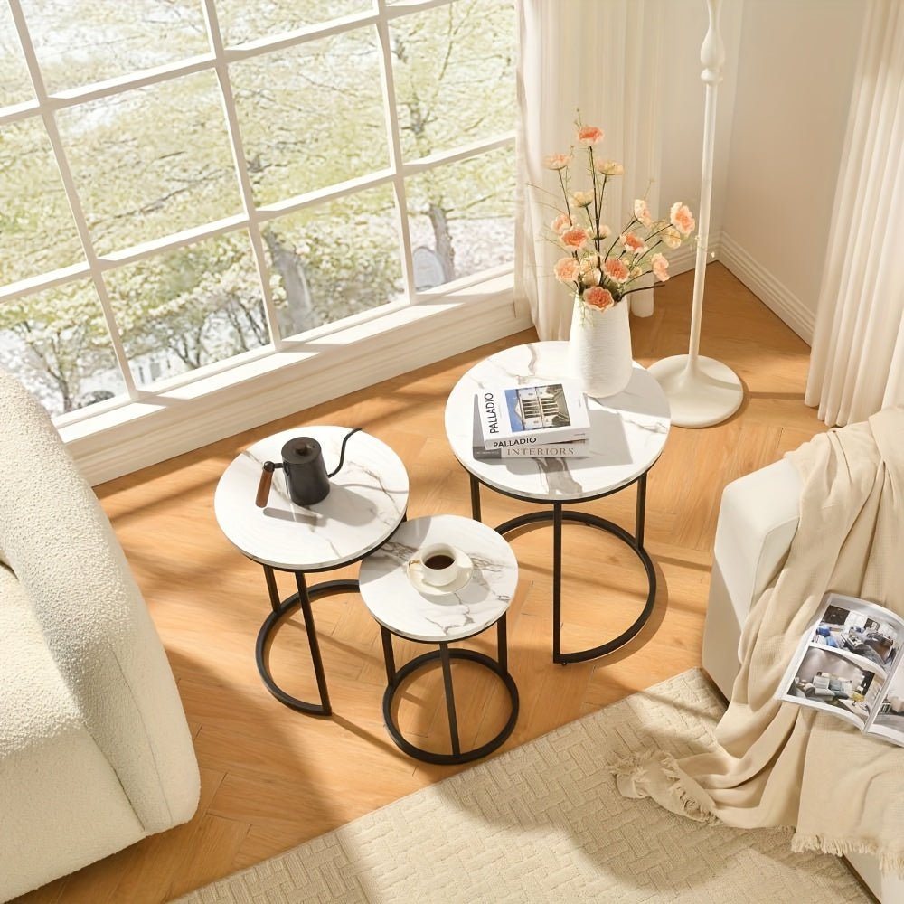 Nutshell modern side table set with white marble tops and black metal frames in cozy living room