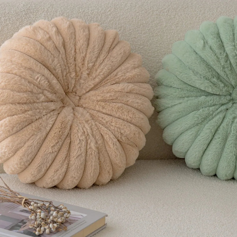 Nutshell round pumpkin pillow cushion in beige and green soft plush fabric on a textured sofa