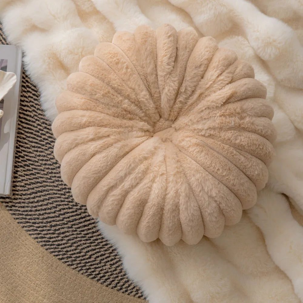 Nutshell beige round pumpkin pillow cushion with soft plush texture on a cozy blanket
