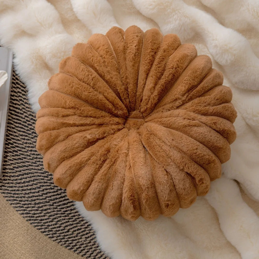 Nutshell soft brown round pumpkin pillow cushion with plush texture on cozy white and patterned rugs