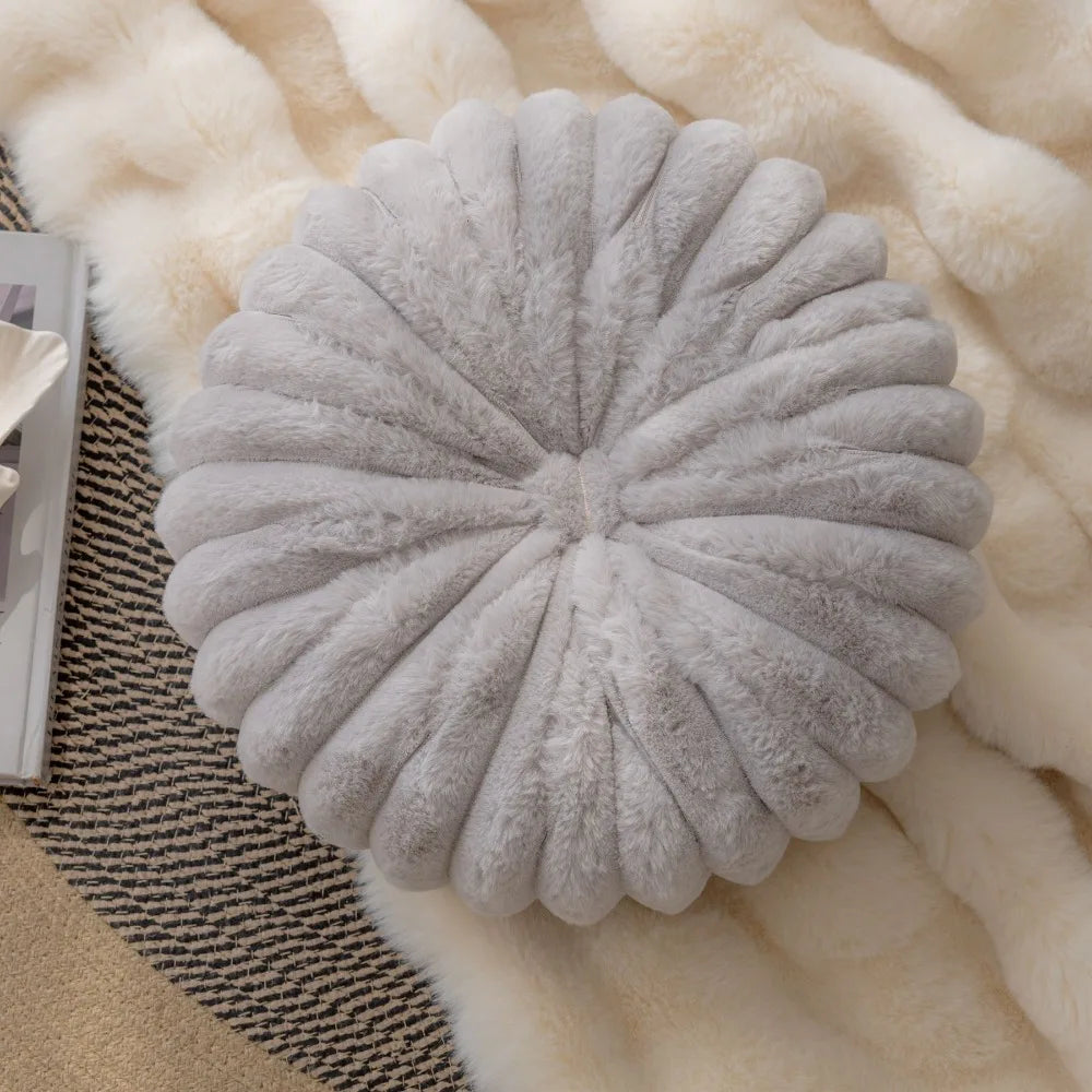 Nutshell soft gray round pumpkin pillow cushion on cozy blankets and a striped rug