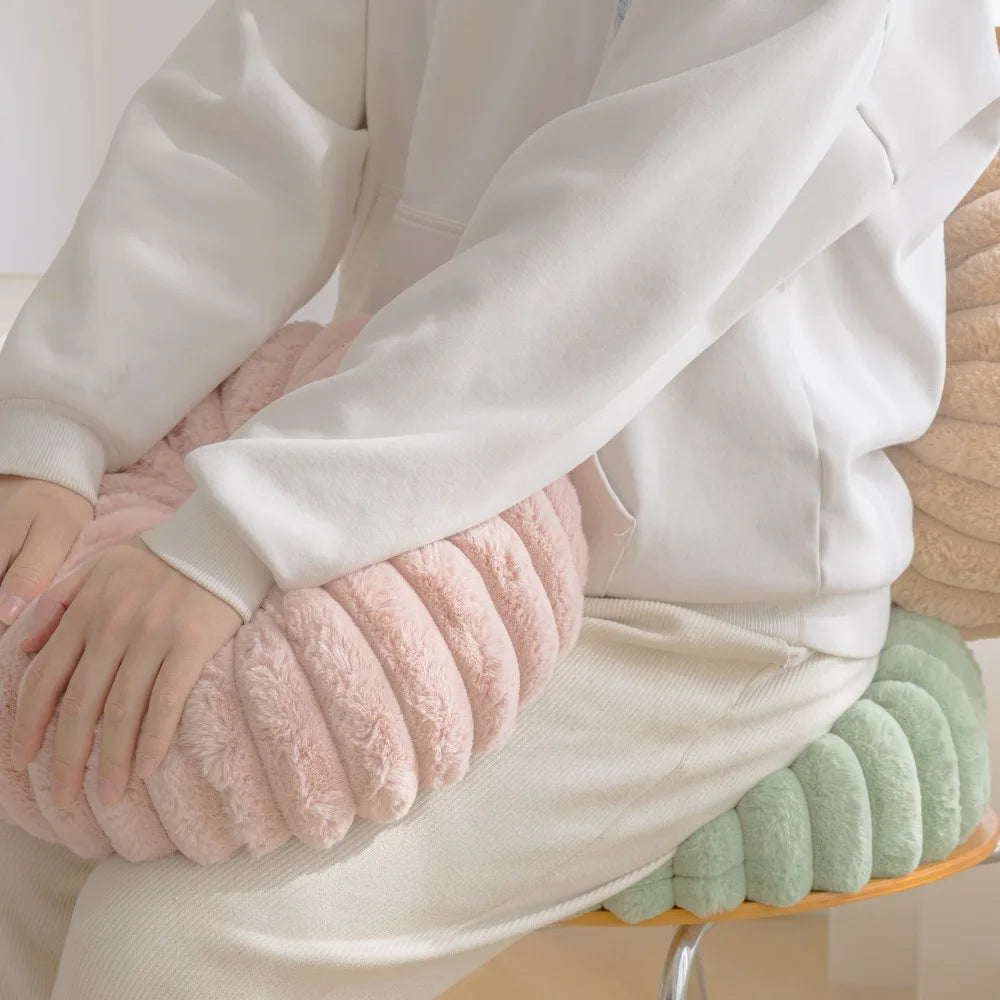 Nutshell soft round pumpkin pillow cushion in pink held by person sitting on green round pumpkin pillow