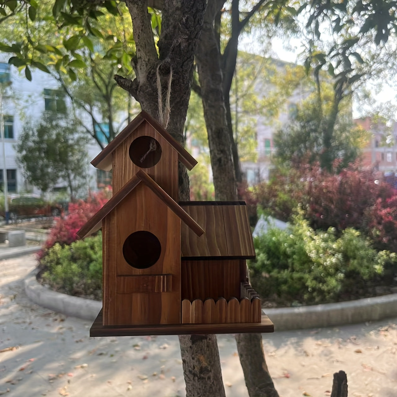 Nutshell Wooden Birdhouse hanging in a garden with decorative design elements