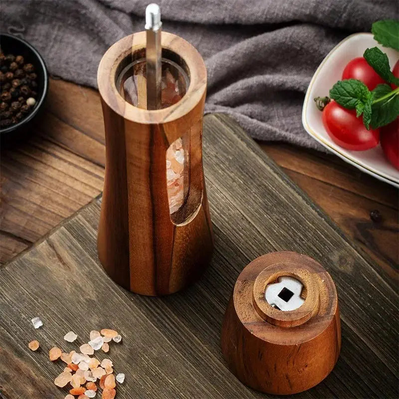 Nutshell wooden salt and pepper grinder set with clear window and ergonomic design on wooden surface