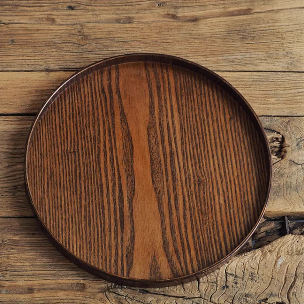 Nutshell round wooden serving tray with rich wood grain on rustic wooden surface
