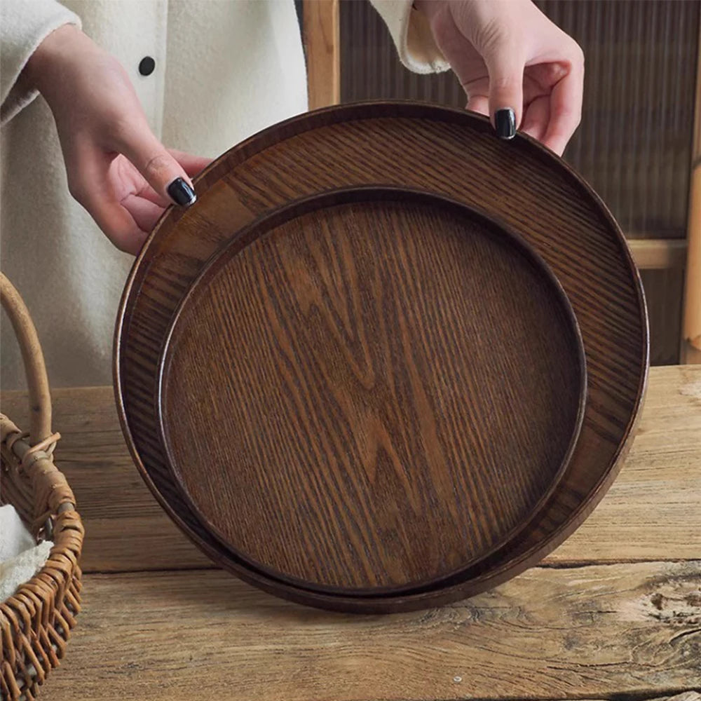 Nutshell wooden serving tray with rich dark wood grain held by hands over wooden table