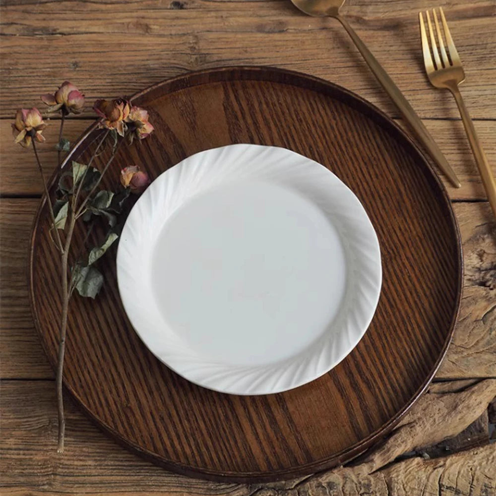 Nutshell wooden serving tray with dark wood finish holding a white plate and dried flowers on rustic wood table