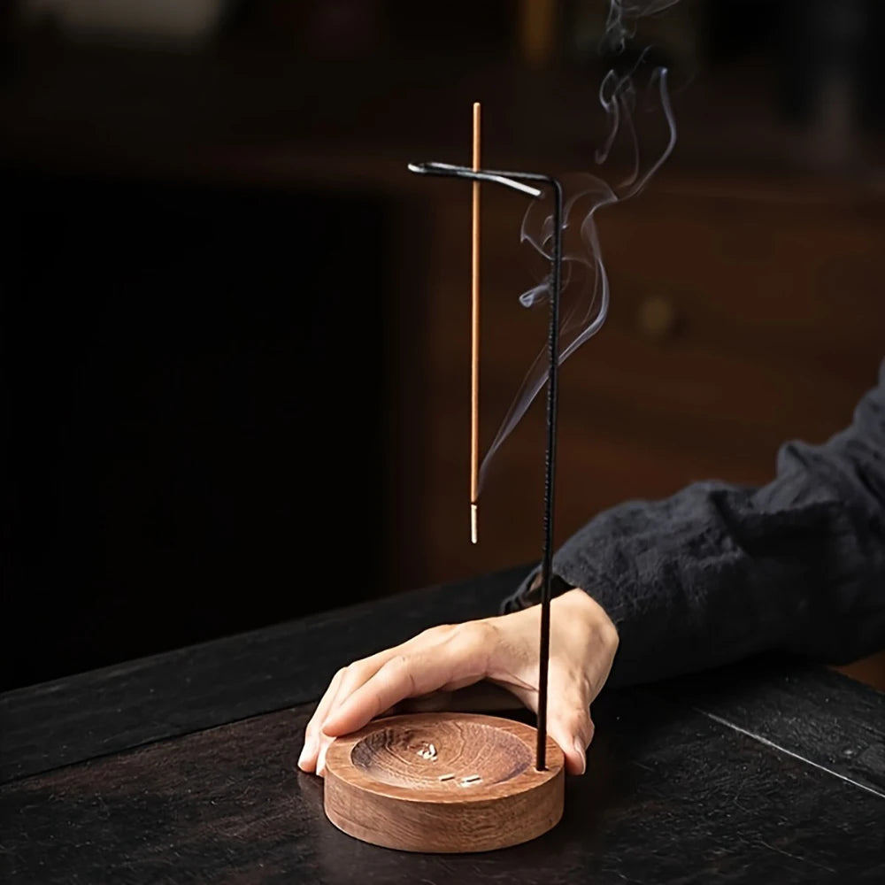 Nutshell anti-ash incense burner with wooden base and vertical metal holder catching ash during use