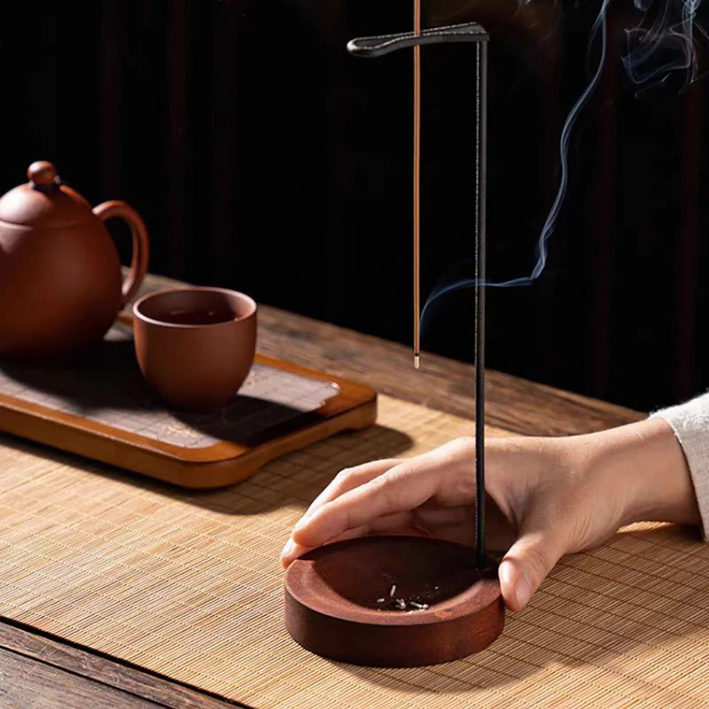 Nutshell anti-ash incense burner with wooden base and vertical metal holder releasing smoke