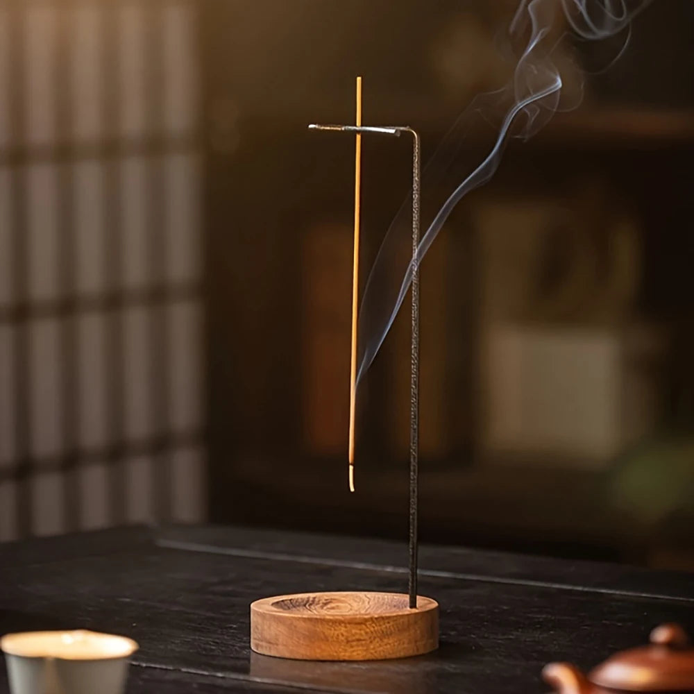 Nutshell anti-ash incense burner with wooden base and suspended holder releasing smoke on dark table