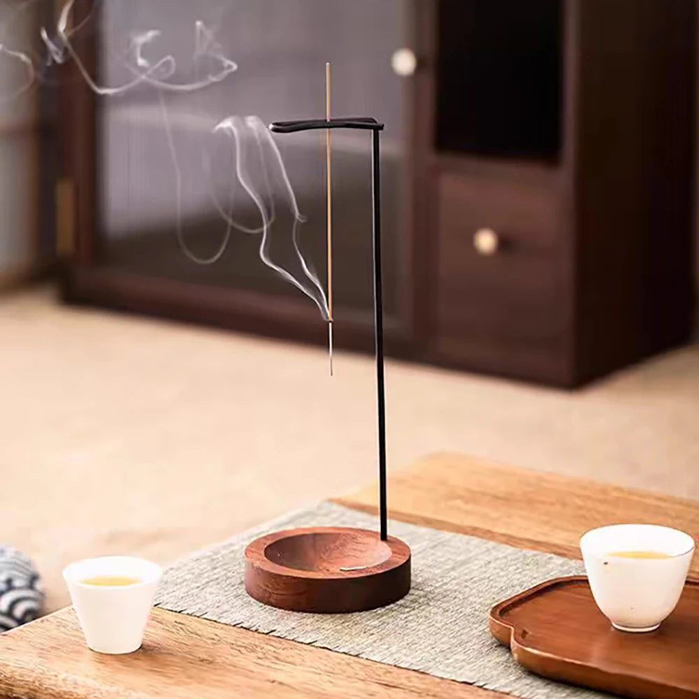 Nutshell anti-ash incense burner with wooden base and hanging incense stick releasing smoke