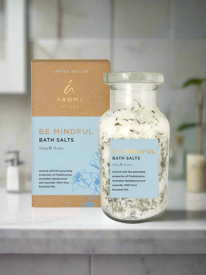 Be Mindful Bath Salts with Frankincense and Lavender in glass jar and packaging on bathroom counter