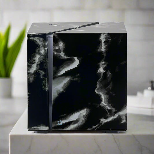 Nutshell black marble essential oil diffuser with sleek cube design on white marble table